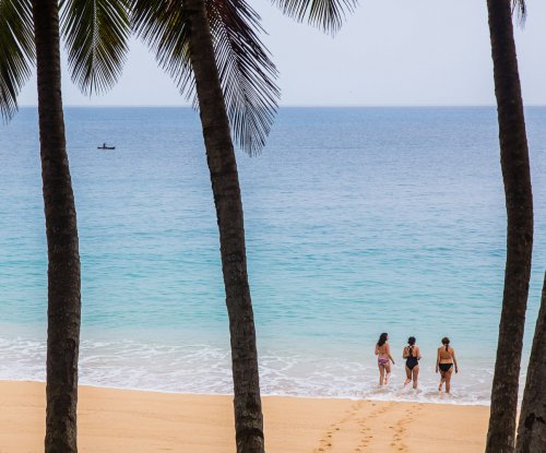 Three tourists standing in the water at Praia Boi on Príncipe Island