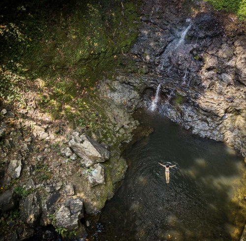 Aerial view of a person floating in the waters of Oque Pipi Waterfall