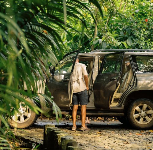 Homem a carregar um carro para uma excursão guiada na Ilha do Príncipe